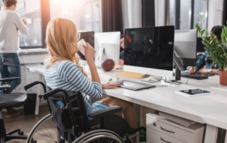 Incapacitated person in wheelchair working at modern office
