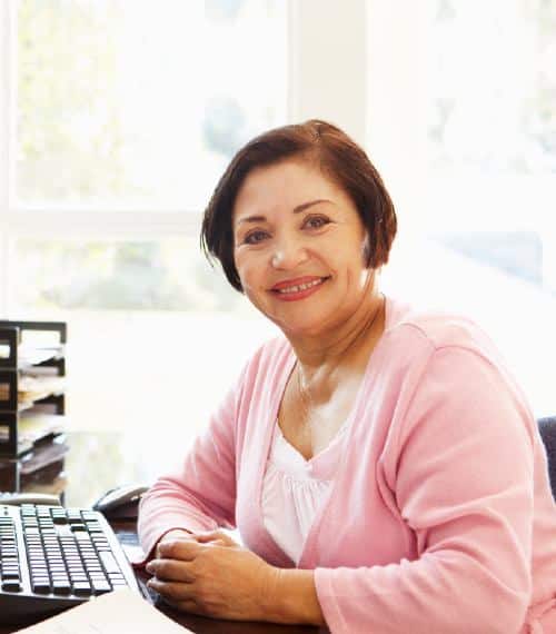 Senior Hispanic woman working on computer in office