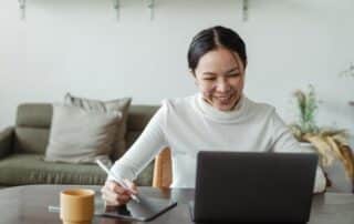 Woman sitting at desk with laptop and tablet